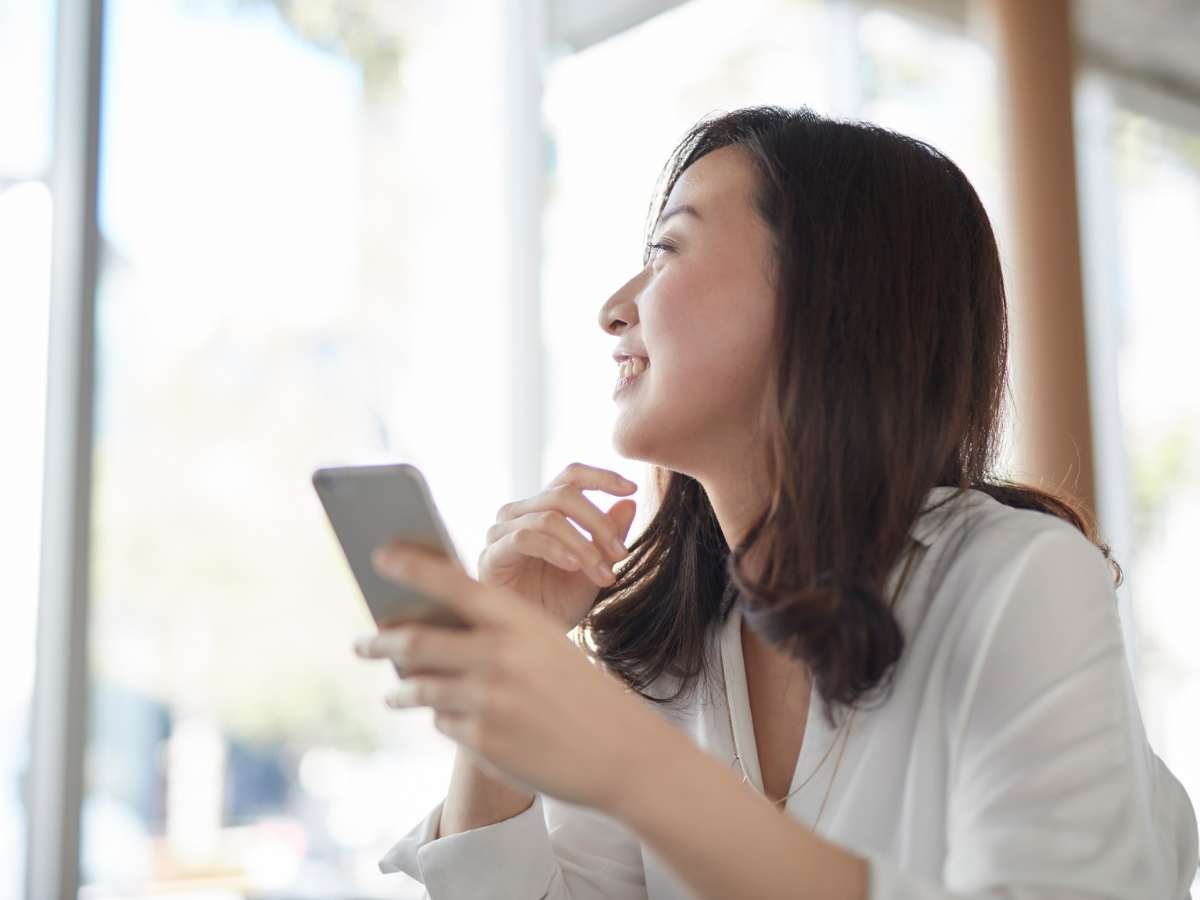 woman smiling on her smartphone eduk
